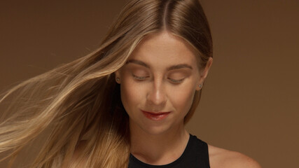 surf style looking blonde girl with hair bloowing looking down