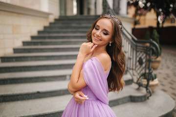 Portrait of elegant woman in purple evening dress walking outdoors by restaurant