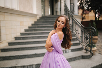 Portrait of elegant woman in purple evening dress walking outdoors by restaurant