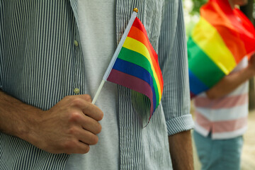 Young men with LGBT flag standing outdoor