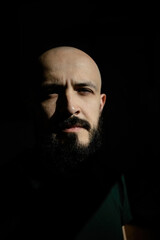 Abstract portrait of a man with a beard in the sun. Minimalism of the forms of light and shadow.