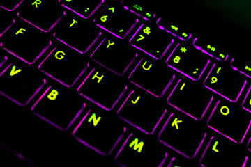 Close up view of a modern laptop computer keyboard key with pink buttonss. Pc computer keyboard close up