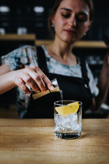 Barista girl prepares a refreshing summer version of iced and syrup coffee - an unconventional recipe