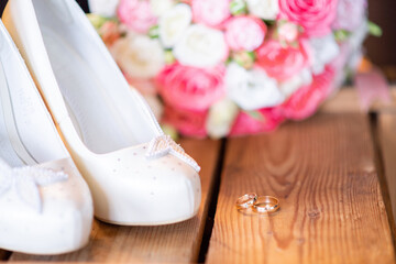 wedding rings on the background of the wedding white shoes