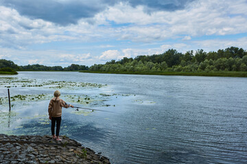 Fototapeta na wymiar Young lady fishing perch on the river