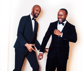 two afro-american businessmen in black suits emotional posing, gesturing, smiling. wearing bow-ties entertaiment stuff