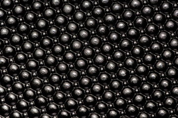 Black dotted plastic surface texture background.