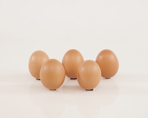 some chicken eggs laid out stand isolated on white background. These health premium eggs are commonly used for advertising or promo materials.