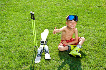 Funny little skier with ski on a green grass. Concept of active healthy lifestyle and waiting for...