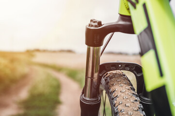 Summer bike ride. Sunny summer day, green sports bike stands on the road. Mountain bike close up. Green mountain bike.