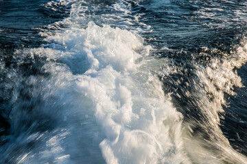 How the sun shimmers on the spray of water of the Adriatic. Big wave and splash.