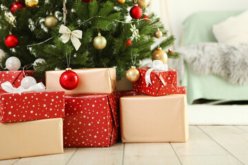 Many gifts under a festively decorated Christmas tree in a bright interior
