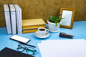 Office workplace documents, glasses, coffee, notebook Blue background