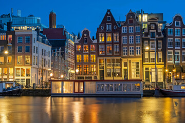 Obraz premium Amsterdam houses and house boats along the Amstel in Amsterdam the Netherlands at sunset