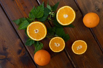 cut oranges on a brown wooden background, top view, text space, citrus fruits