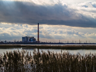Gloomy landscape, waste recycling plant next to the lake