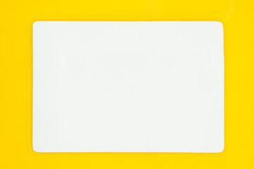 A rectangle empty white plate isolated on the yellow background.