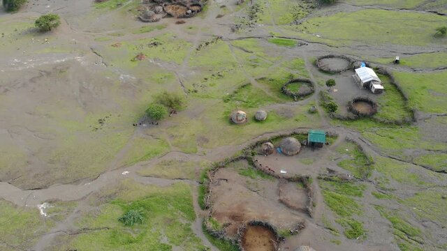 Aerial Flyby View on the Maasai village in front of the Ol Doinyo Lengai, Mountain of God in the Maasai language, Engare Sero village in Arusha Region i the Northern Tanzania, Africa, at Sunset time.