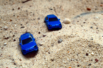 Blue cars in sandpit. 