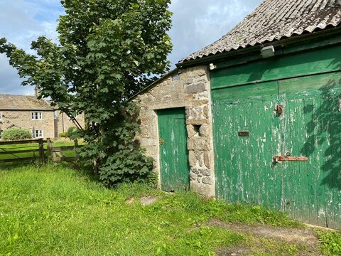 Old  empty stone building, with a tree by the green door in, Hetton, Skipton, UK