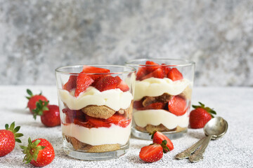 Strawberry tiramisu in a glass on a concrete background. Classic Italian dessert.
