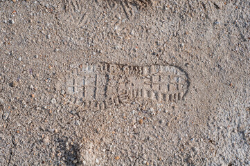 Footprint on clay soil from shoes, close-up, natural material, atmospheric influence, outdoors.