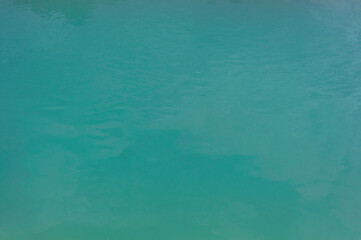 Background close-up, turquoise green water surface lake, outdoors.