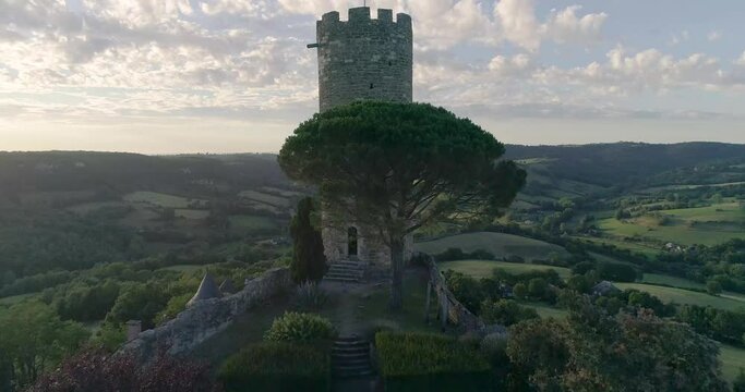 drone au dessus de Turenne en Corr&egrave;ze, cit&eacute; m&eacute;di&eacute;val avec ch&acirc;teau entour&eacute; par un petit village en France pendant le couch&eacute; du soleil avec des jardins en hauteur 