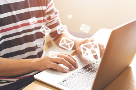 Email Marketing And Newsletter Concept. Hand Of Man Sending Message And Laptop With E-mail Icon