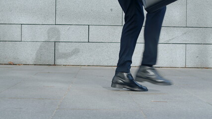Businessman legs jumping on city street. Male professional dancing on street