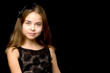 Fototapeta na wymiar Close-up.Portrait of a cute little girl on a black background.