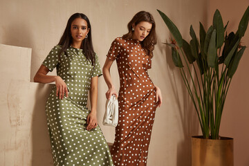 Two fashion model brunette hair wear green  brown dots silk dress sandals  accessory clothes date...