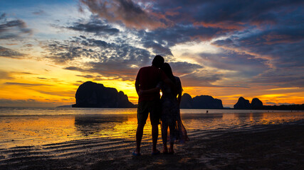 Beautiful sky sunset with couple lover at Pakmeng beach, Trang Province, Thailand