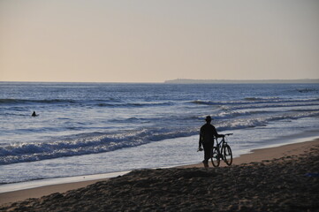Man with bicycle at sunset at Playa El Palmar, Vejer de la Frontera, Cádiz, Andalusia, Spain