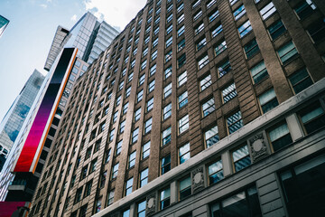 High raised modern building with offices and headquarters of companies in business center of megalopolis, skyscraper exterior with windows of apartment and real estate for rent in downtown .