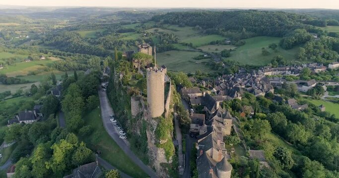 drone au dessus de Turenne en Corr&egrave;ze, cit&eacute; m&eacute;di&eacute;val avec ch&acirc;teau entour&eacute; par un petit village en France pendant le couch&eacute; du soleil avec des jardins en hauteur 