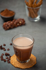 Cocoa served with a delicious chocolate dessert on a black background..