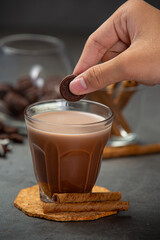 Cocoa served with a delicious chocolate dessert on a black background..