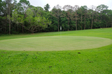Background of evening golf course has sunlight shining down at golf course in Thailand. Nice scenery on a golf course at a late summer afternoon