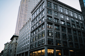 Modern constructed concrete building with offices and headquarters inside in business center of megalopolis, exterior view of skyscraper with windows of rental apartments real estate in usa.