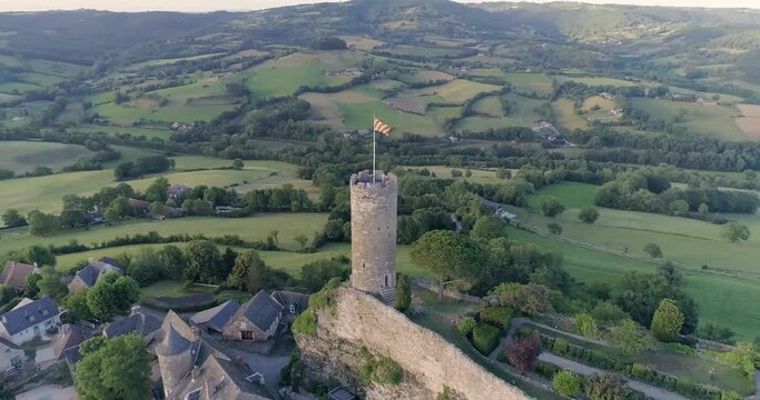drone au dessus de Turenne en Corr&egrave;ze, cit&eacute; m&eacute;di&eacute;val avec ch&acirc;teau entour&eacute; par un petit village en France pendant le couch&eacute; du soleil avec des jardins en hauteur 