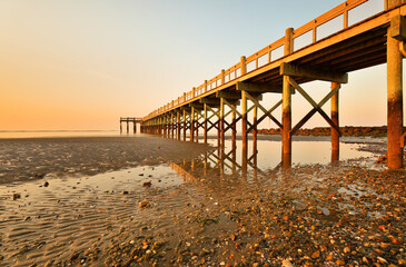 Overview of beautiful fishing pier after sunset at low tide at Walnut Beach, Milford Connecticut,...