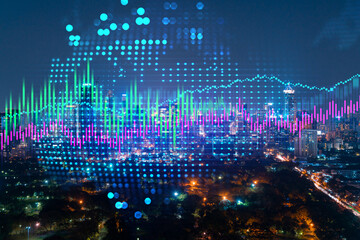 Stock market graph hologram, night panorama city view of Bangkok, popular location to gain financial education in Asia. The concept of international research. Double exposure.