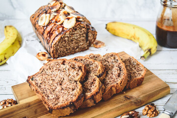 Banana bread with chocolate, decorated with slices of banana and chocolate syrup