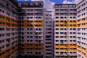 Modern urban architecture concept; wide angle symmetry shot. Exterior of typical public housing (HDB flats) in Singapore canberra estate on sunny day. Graphical.