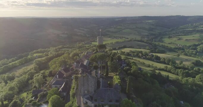 drone au dessus de Turenne en Corr&egrave;ze, cit&eacute; m&eacute;di&eacute;val avec ch&acirc;teau entour&eacute; par un petit village en France pendant le couch&eacute; du soleil avec des jardins en hauteur 