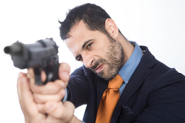 manager vestito in abito con una cravatta arancione punta una pistola e mira pronto a sparare ,...