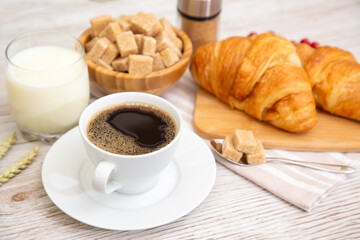 Breakfast in the morning with black coffee cup with bread with Croissant and fruit on the wooden table.