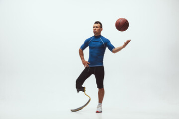 Athlete with disabilities or amputee on white studio background. Professional male basketball...