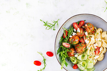 Italian pasta. Conchiglie with meatballs, feta cheese and salad on light background. Dinner. Top view, overhead. Slow food concept